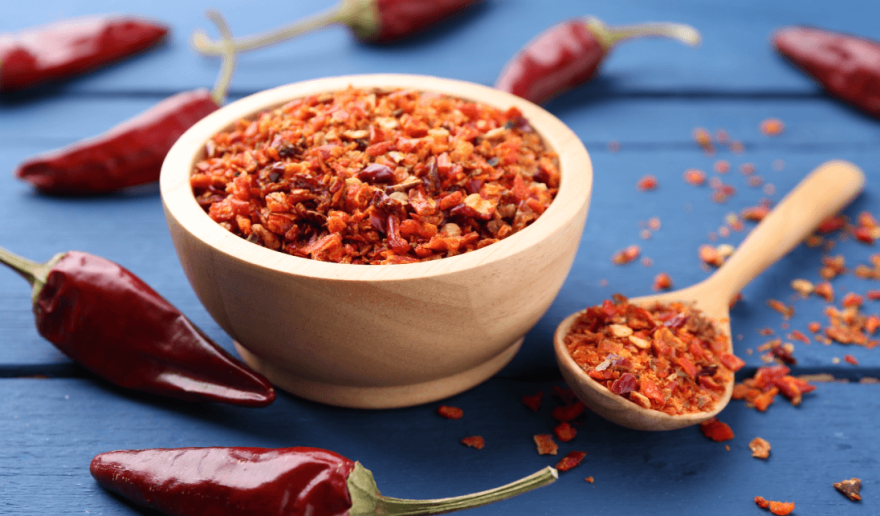 Cos-estournel-piment-Chili,Pepper,Flakes,And,Pods,On,Blue,Wooden,Table,,Closeup